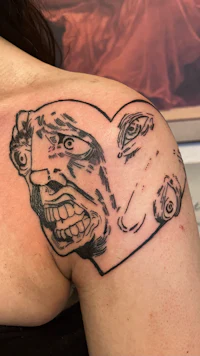 a woman with a tattoo of a face on her shoulder