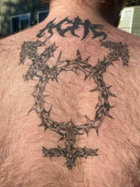 a man's back with a tattoo of a cross and thorns