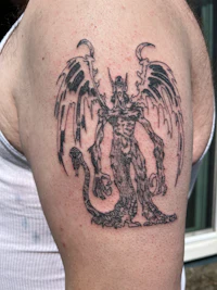 a tattoo of a demon on a man's arm