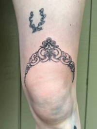 a tattoo of a crescent moon on a person's leg