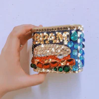 a person holding up a colorful cuff bracelet