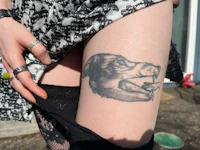a woman with a tattoo of a dog on her thigh