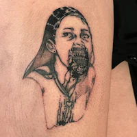 a tattoo of a woman with a mouth on her thigh