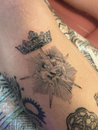 a woman's leg with a tattoo of a crown and a star