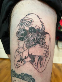 a black and white tattoo of a woman with flowers on her thigh